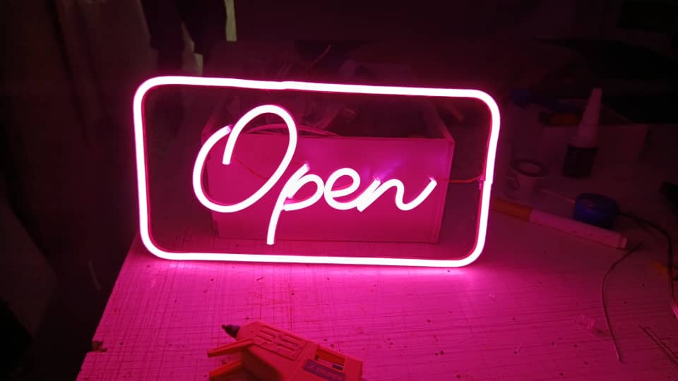 Cartel neón de 30 × 15 cm, elaborado con fondo en acrílico transparente de 3 mm y palabra “OPEN” o “ABIERTO”